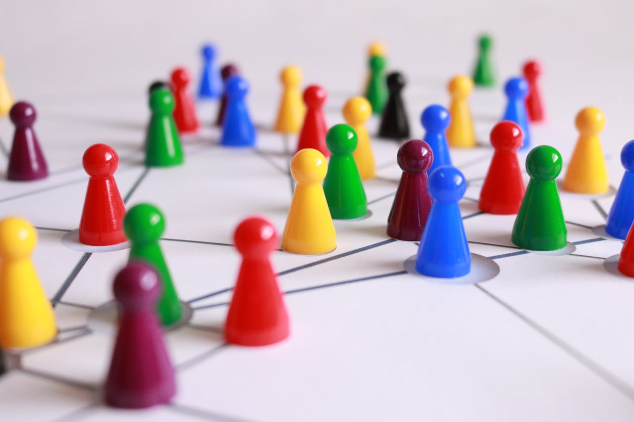 about-us-01 A strategic arrangement of colorful pawns connected on a game board, symbolizing networking and teamwork.