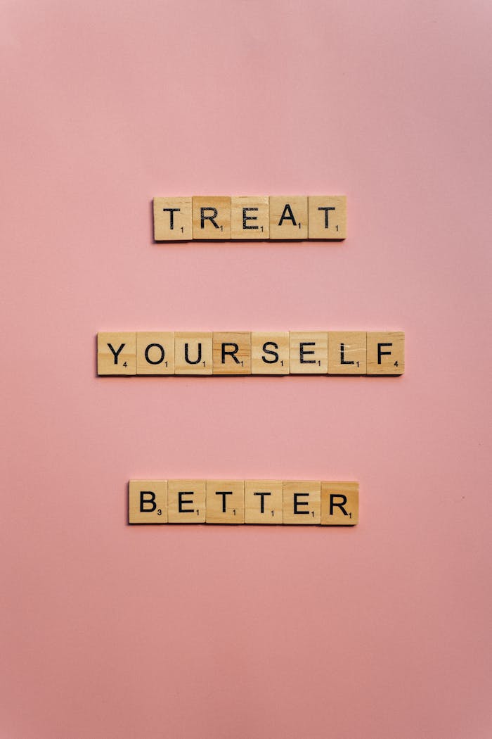 services-01 Scrabble tiles spelling Treat Yourself Better on a pink background.